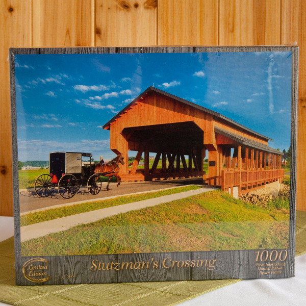 Rejoice at the return of family time with this challenging 1,000-piece puzzle of the famous covered bridge in Walnut Creek, Ohio, named for the pioneer, Jonas Stutzman. Adults and children 12 and up will enjoy collaborating on their recreation of a gorgeous Doyle Yoder "Saturday Morning" photo. The finished family masterpiece will measure 20 inch x 27 inch, an ideal size for framing.