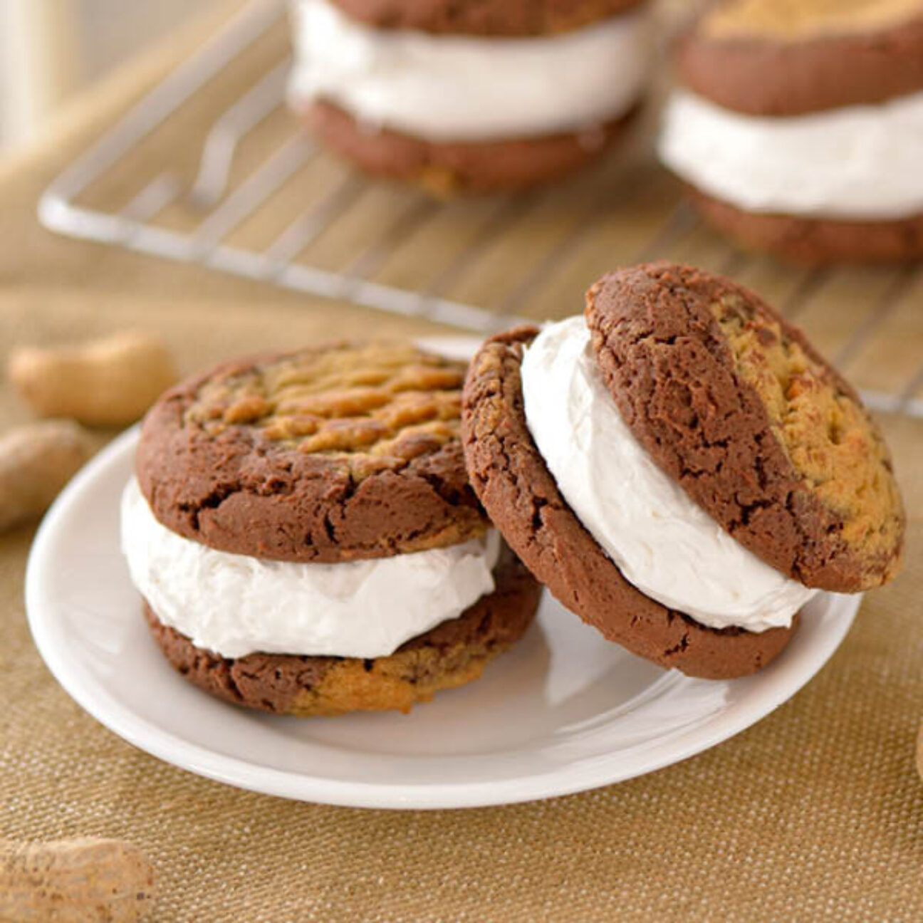 Chocolate Peanut Butter Swirl Cookies surround a layer of white fluffy vanilla filling. 