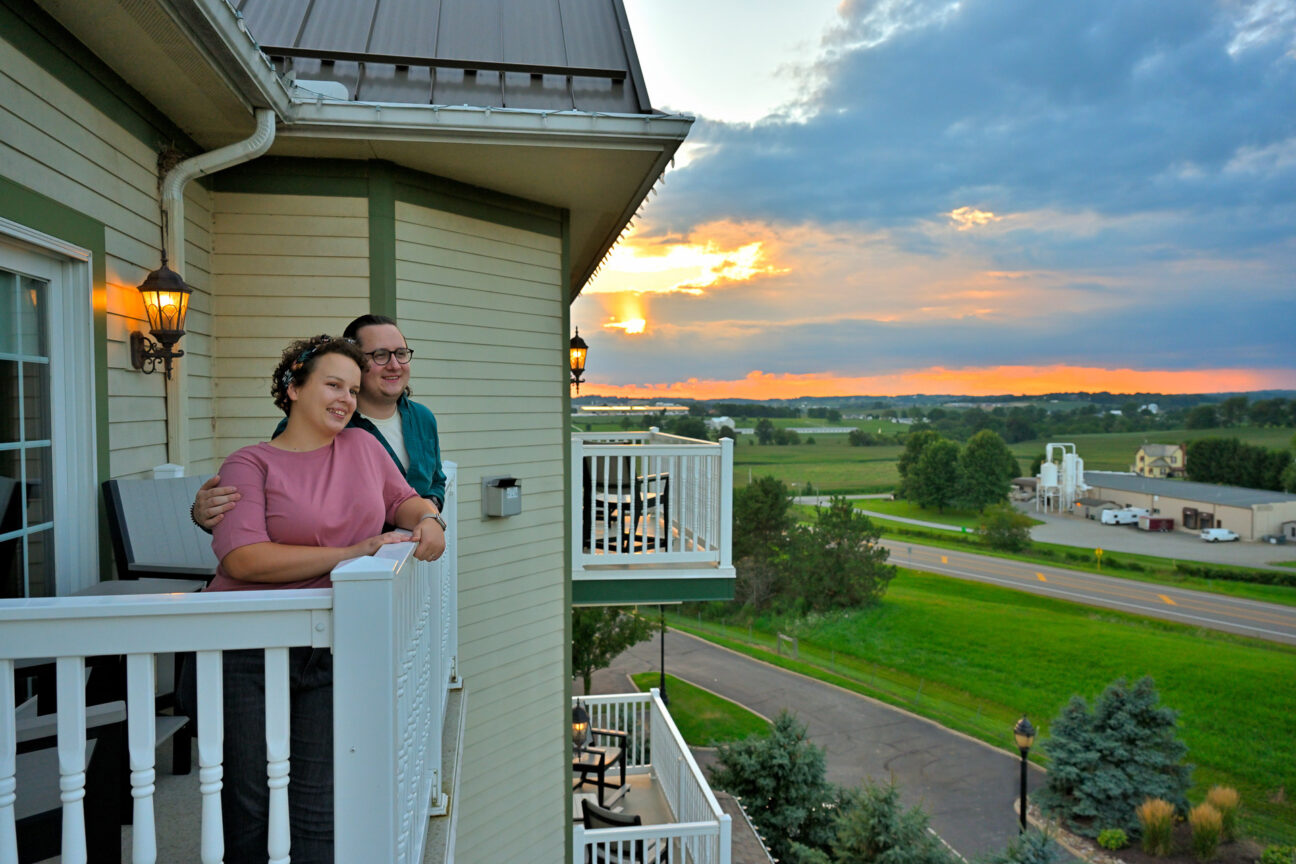 Couple on outdoor balcony at Carlisle Inn at sunset
