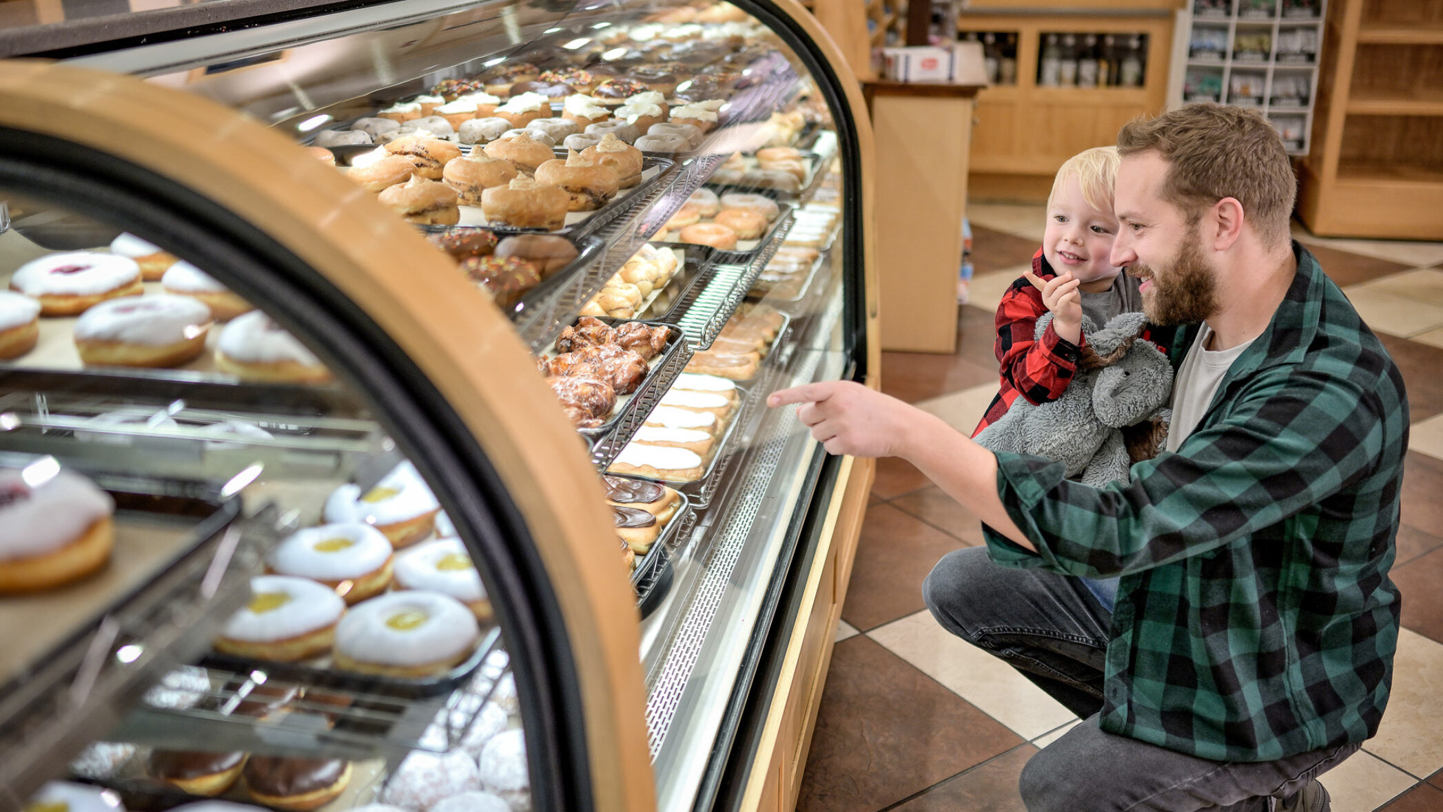 Father with child pointing at Dutch Valley bakery items behind glass