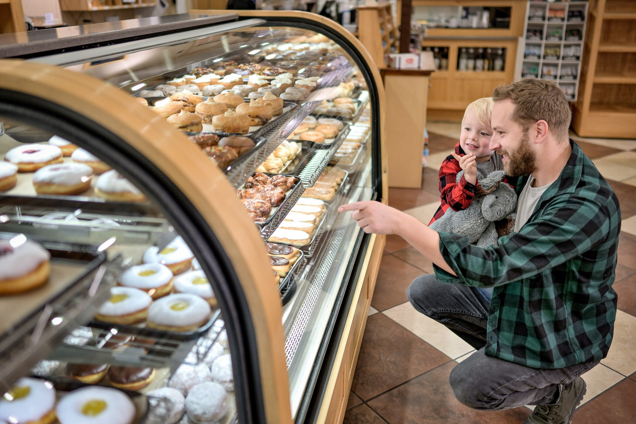 Father with child pointing at Dutch Valley bakery items behind glass